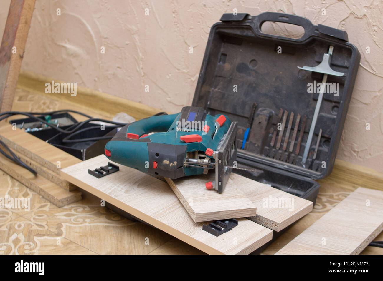 Lying on the floor is a joiner tool electric jig saw after cutting Stock Photo