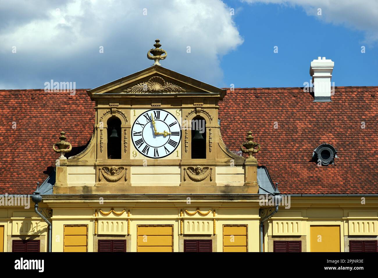 white round clock in decorative yellow brick exterior wall. black roman