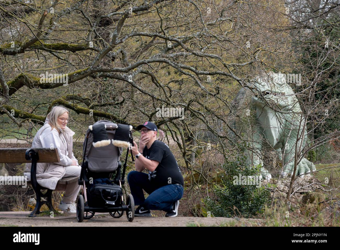 Visitors admire the victorian era grade i listed dinosaur sculptures in