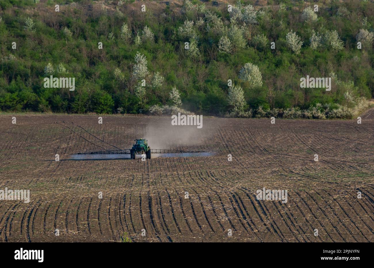 Tractor spray fertilizer spraying pesticides on green field