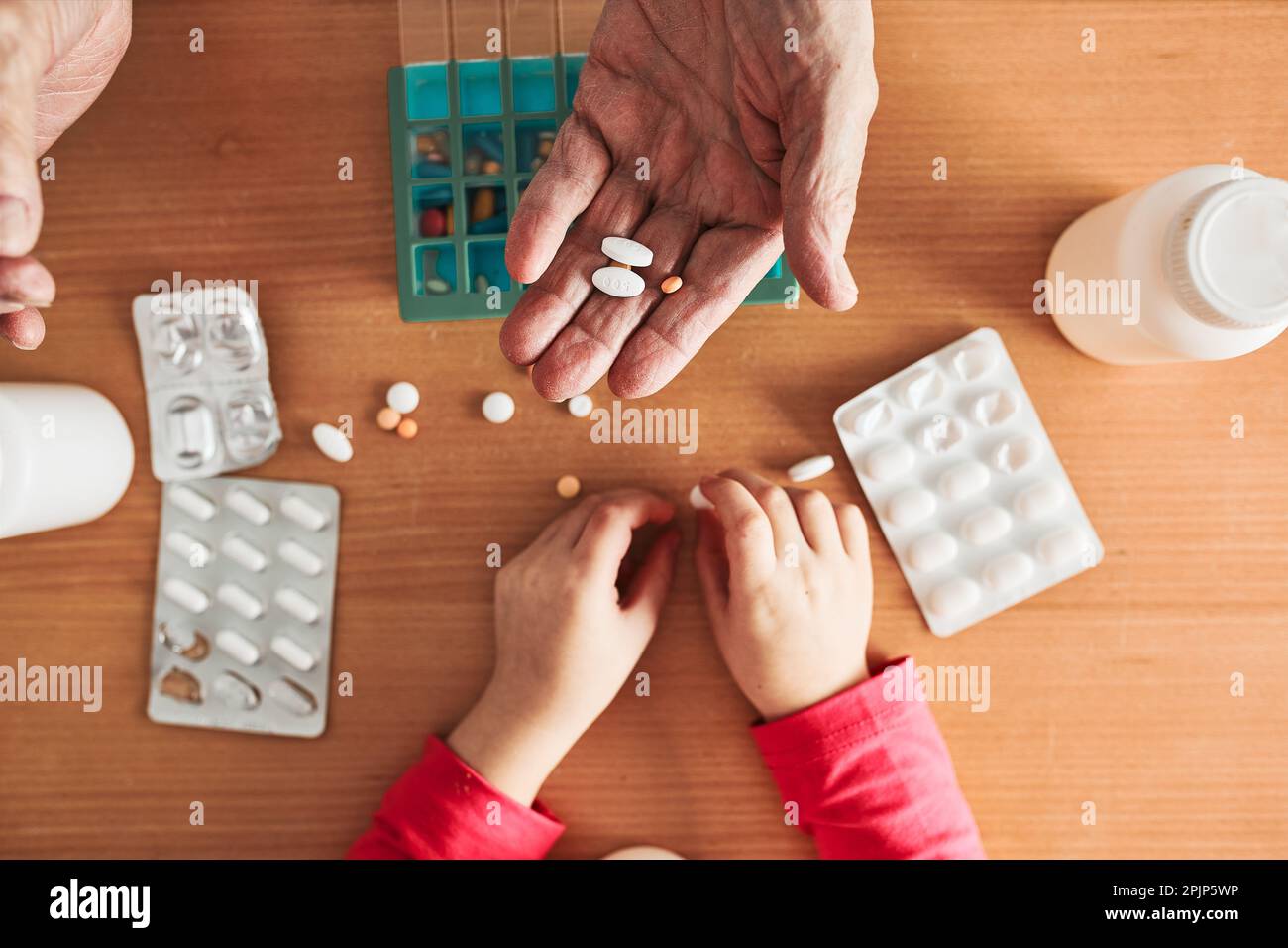 Grandchild helping grandfather to organize medication into pill dispenser.  Senior man taking pills from box. Healthcare and old age concept with medic  Stock Photo - Alamy