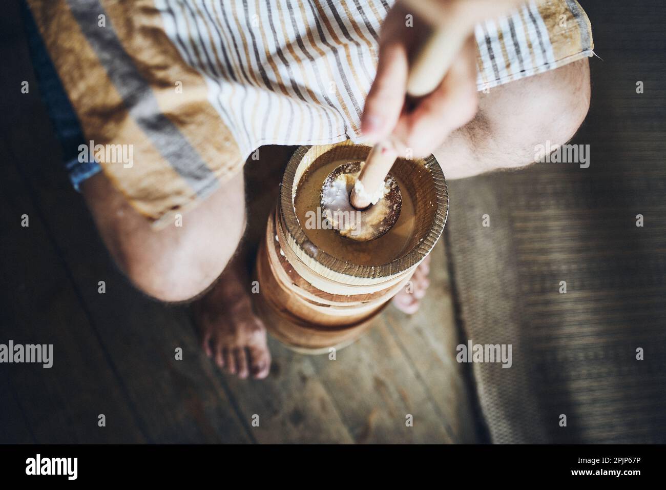 Man making butter with butter churn. Old traditional method making of butter Stock Photo