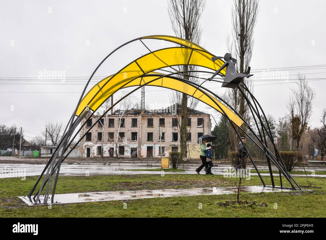 The sculpture 'Girl under the sun' is visible against the background of a destroyed house. The sculpture 'Girl under the sun' was opened in Borordyanka in honor of the anniversary of the de-occupation of Kyiv region. The four-meter sculpture represents the victory of life over destruction, and its arches will symbolize the resistance of seven districts of Kyiv region and the capital. This is how the symbolic date was celebrated - a year ago, the Armed Forces of Ukraine completely liberated the Kyiv region from the Russian invaders. 'The sculpture reflects the powerful contrast of life and dest Stock Photo