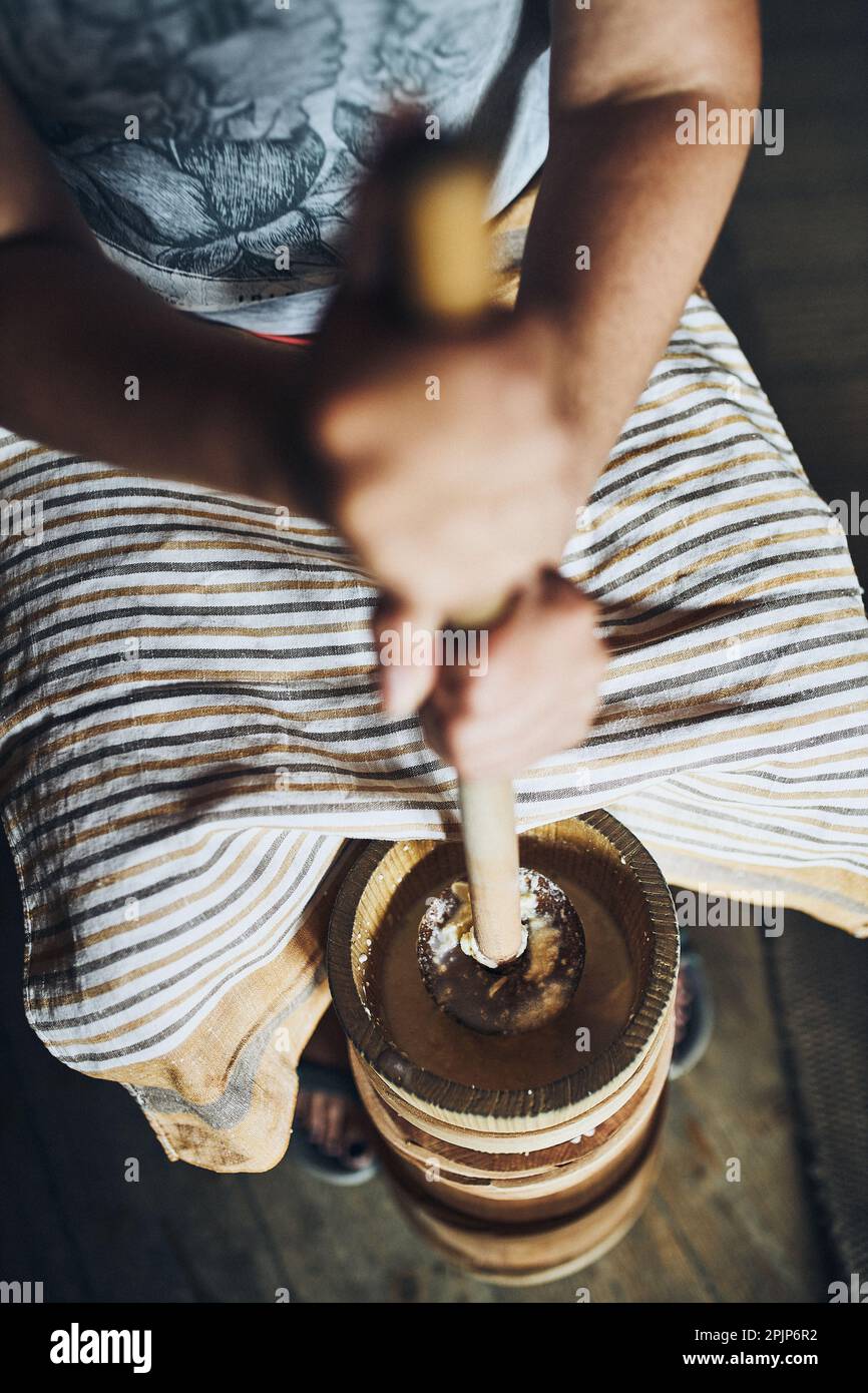 Woman making butter with butter churn. Old traditional method making of butter Stock Photo
