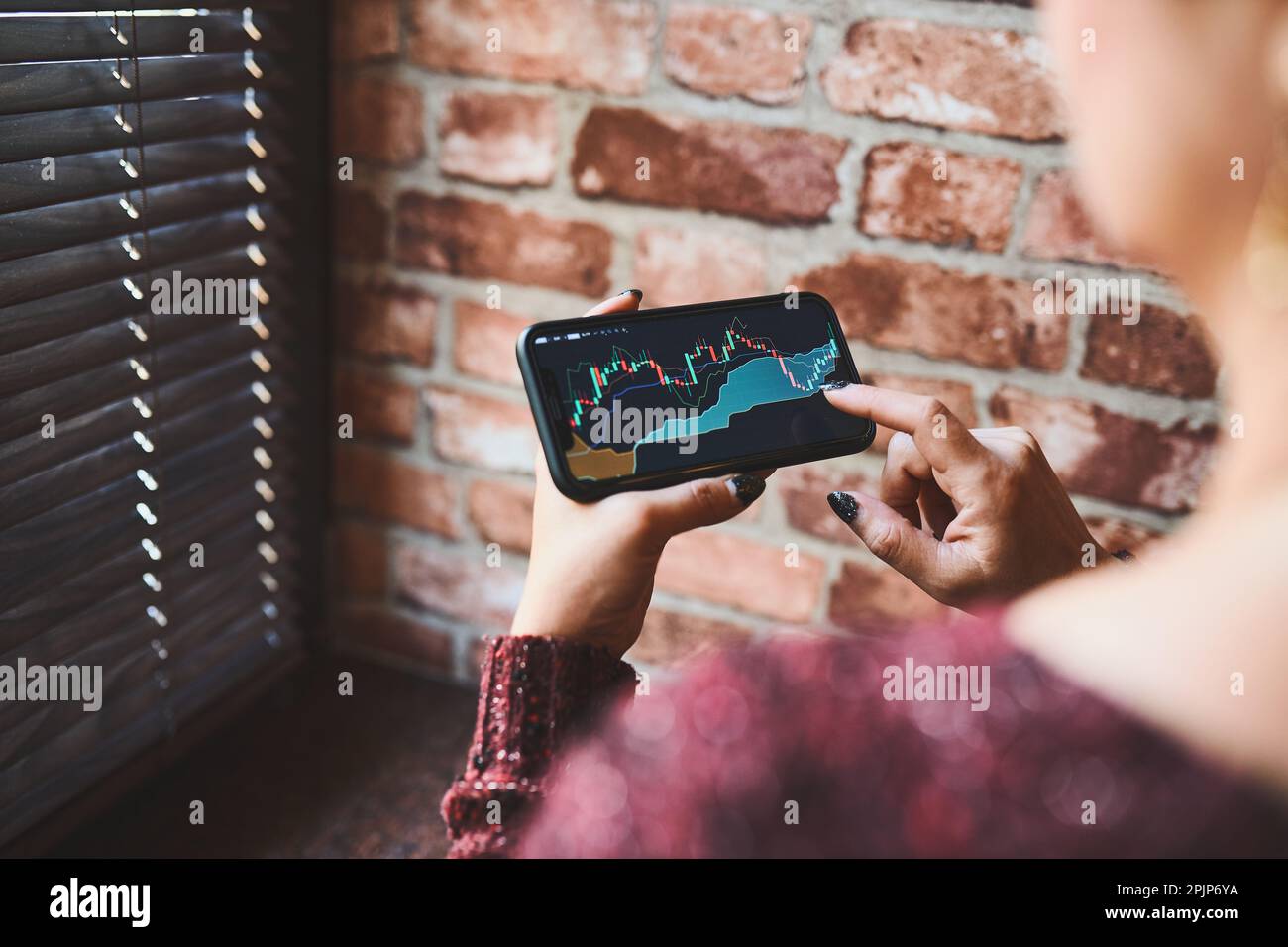 Person investing trading on stock cryptocurrency market using investing application on smartphone. Stock market investment in hand. Trader holding mob Stock Photo