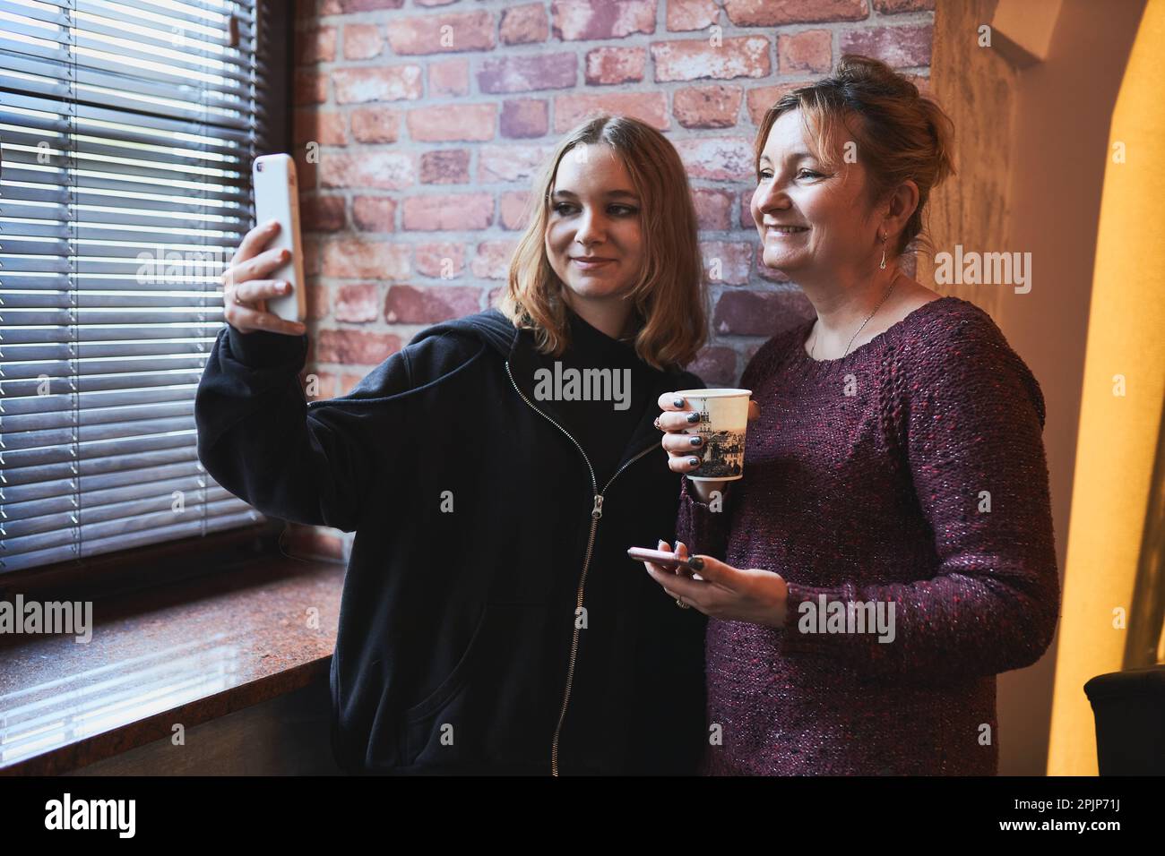 Women making video call on mobile phone.  Taking selfie photo using smartphone. Connecting remotely with family and friends Stock Photo