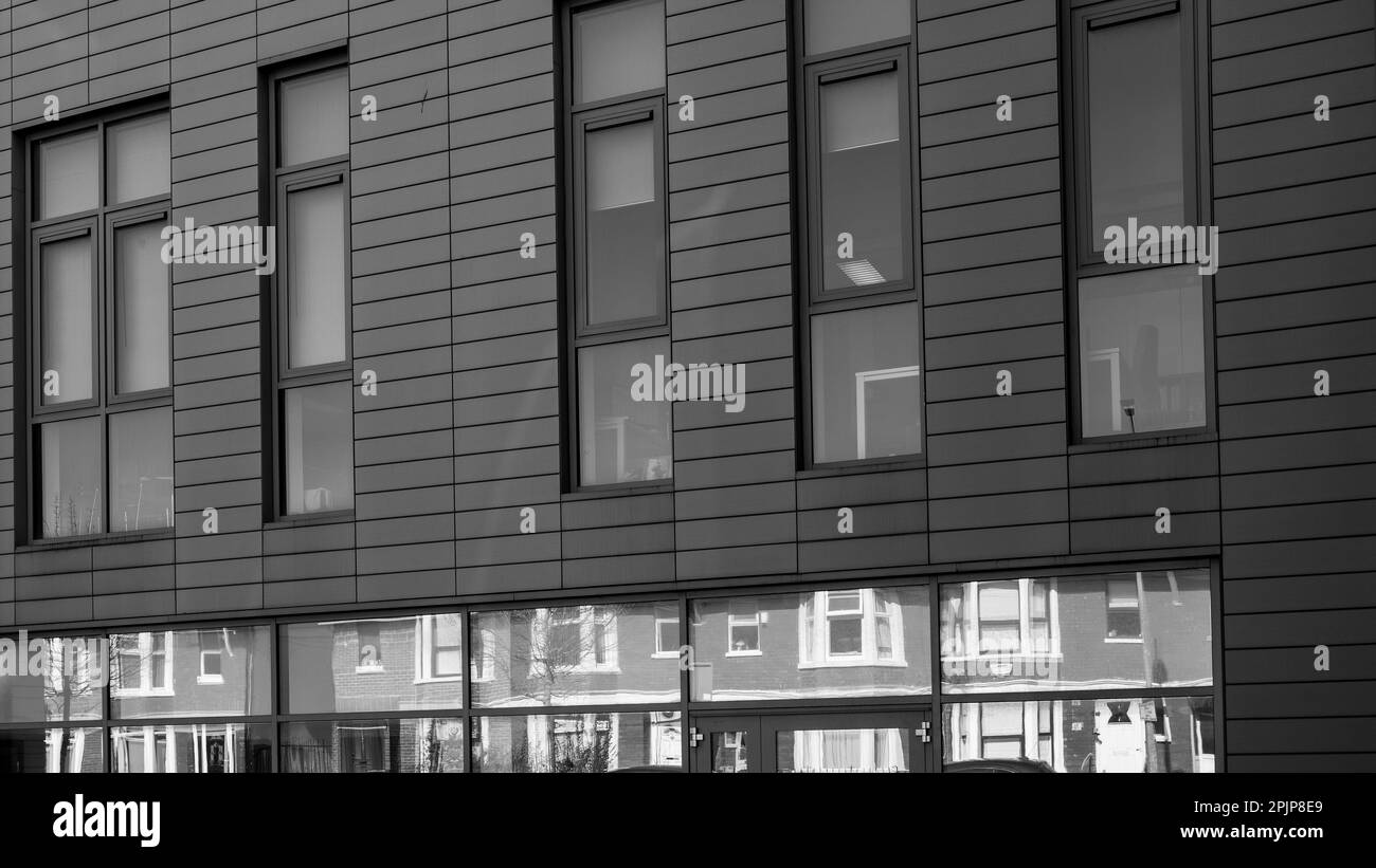 Contrasting architecture - old reflected in the new. Terrace houses and modernist building. Concept. Abstract. Black and White Image Stock Photo
