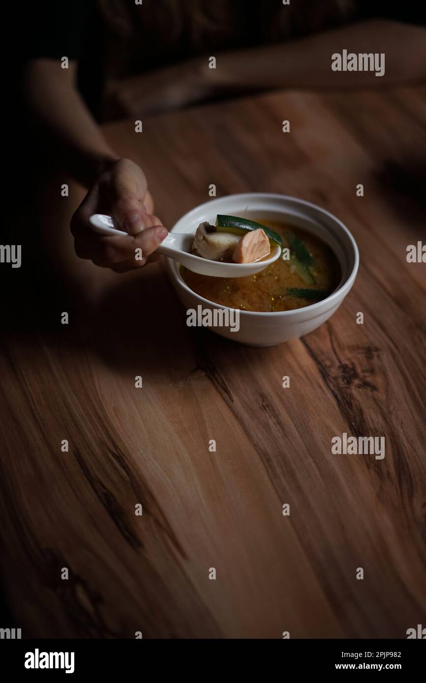 Japanese cuisine: Miso soup with salmon on a wooden table Stock Photo
