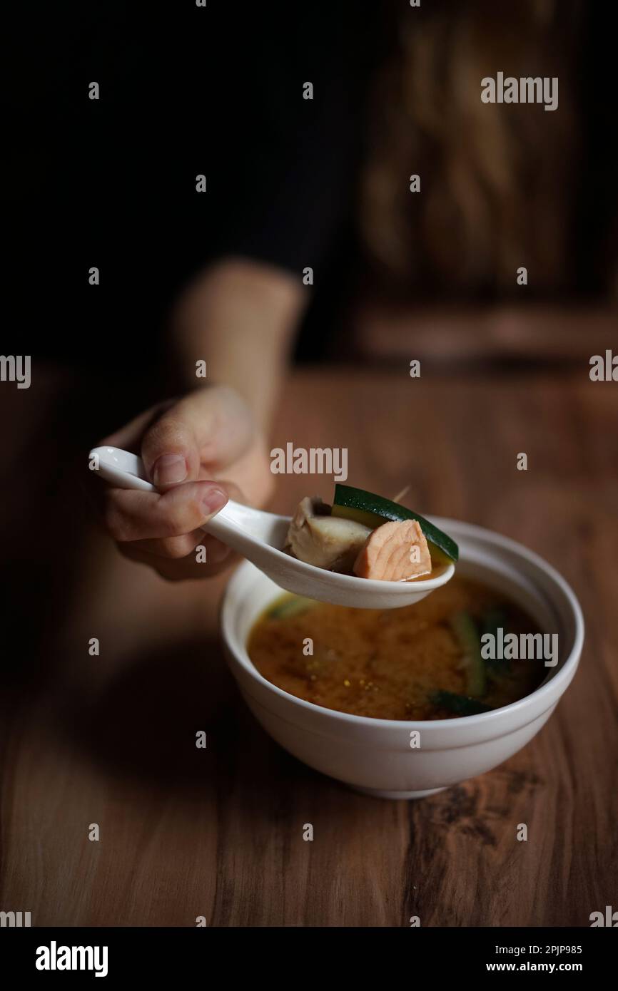 Japanese cuisine: Miso soup with salmon on a wooden table Stock Photo