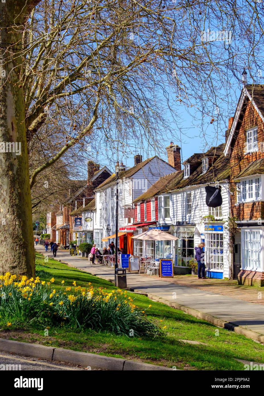 Elegant shops and cafes along the wide pavement on Tenterden High Street, Kent, UK Stock Photo