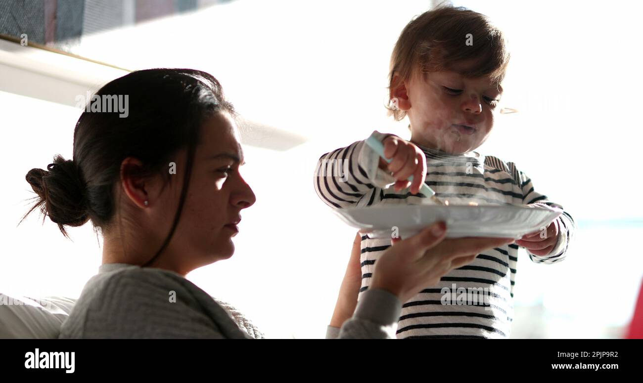Funny baby toddler feeding mother reversing the roles. Adorable child ...