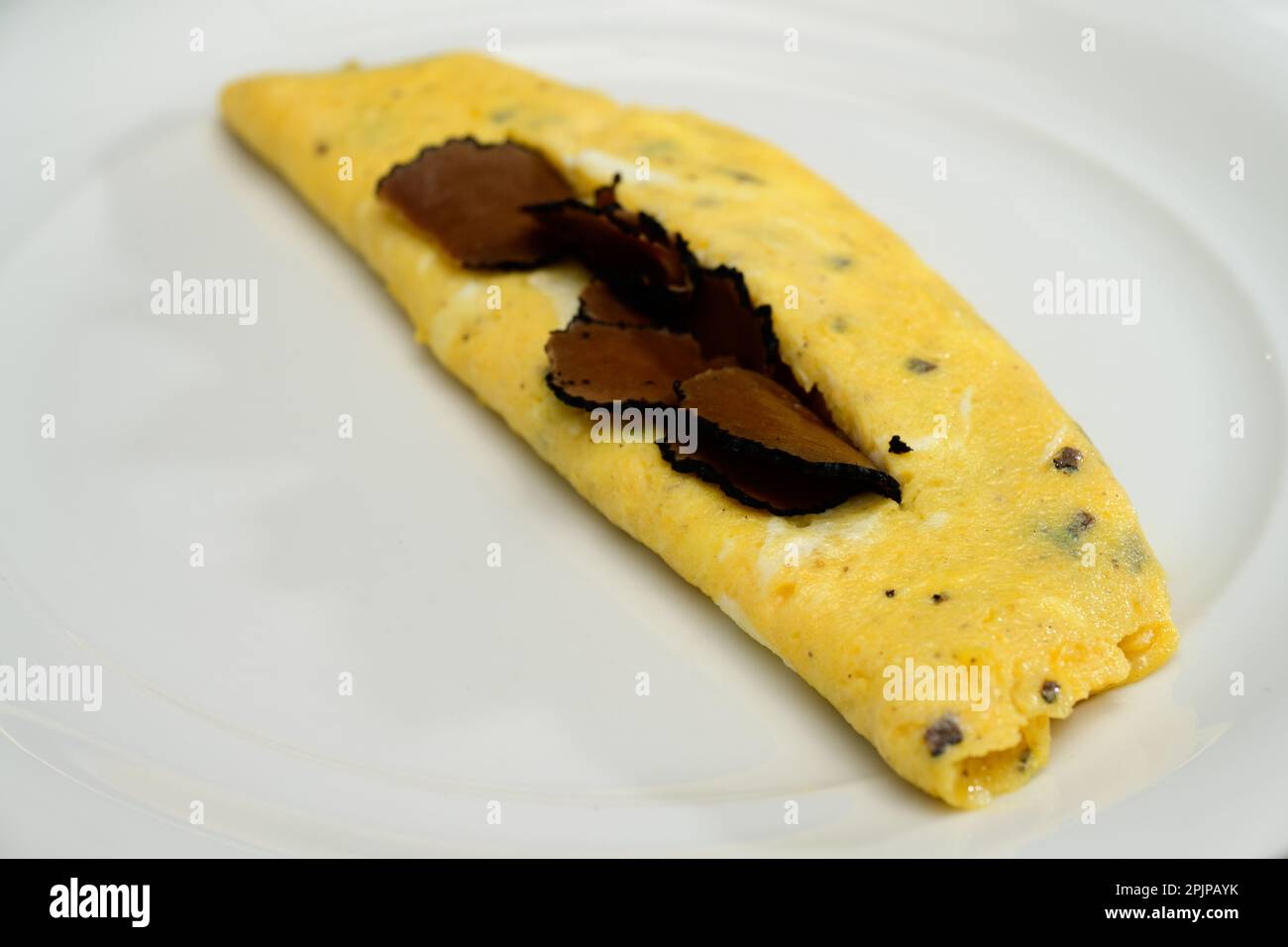 French Truffle Omelette Eggs or Omelette auc Truffes with Black Summer Truffles on a White Plate Stock Photo