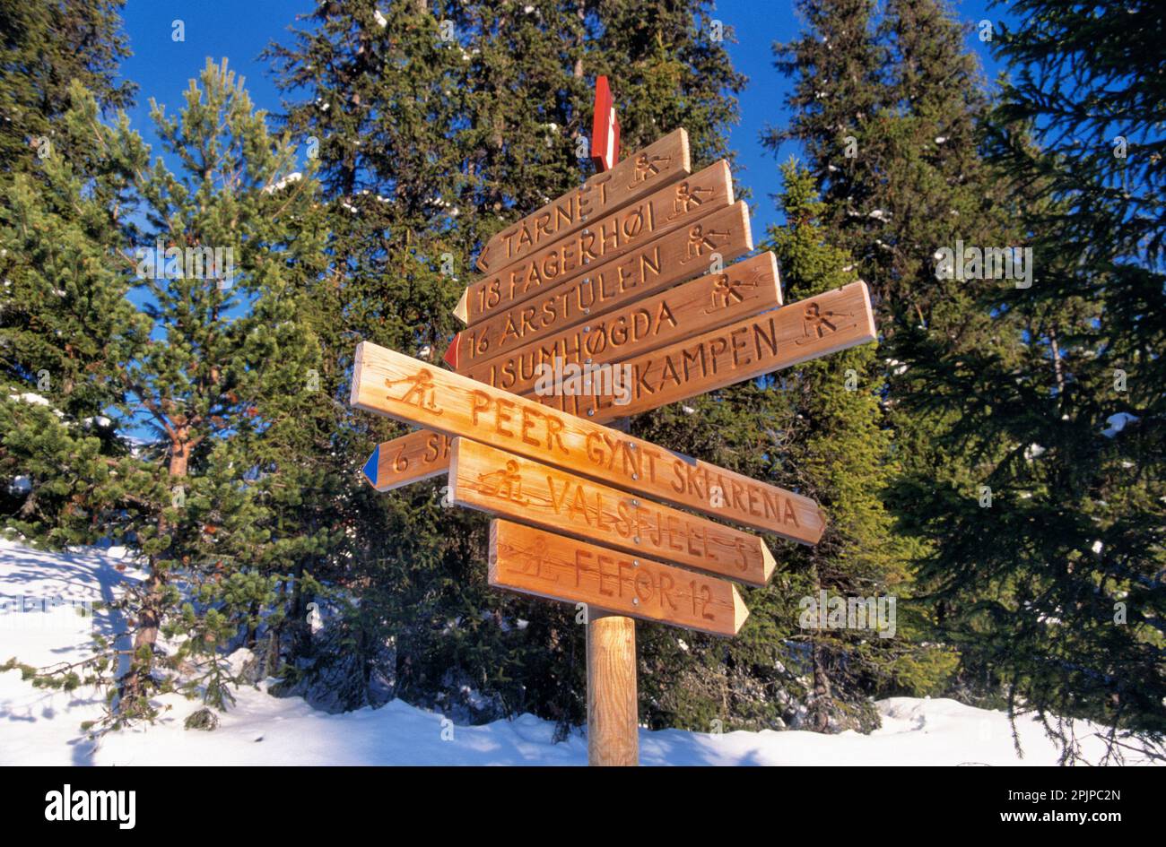 Wooden sign post with directions for cross-country skiers to destinations and distances at the Peer Gynt ski arena in Norway Stock Photo