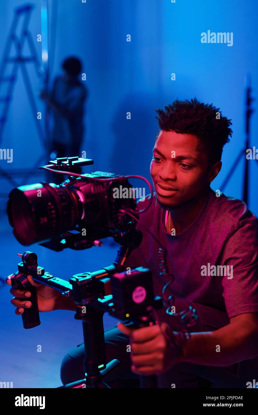 African American camera operator using professional camera to shoot