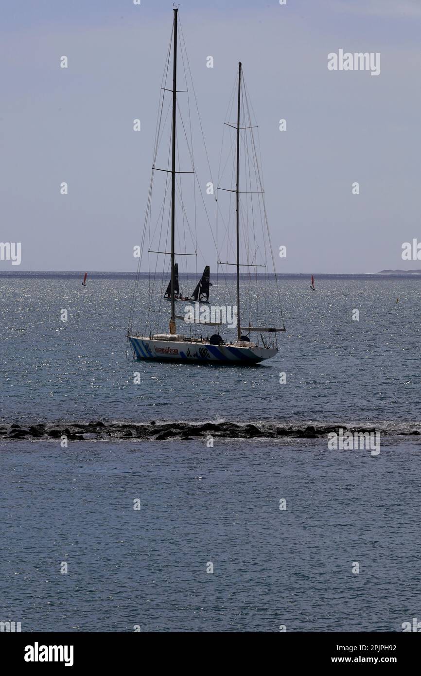 Tall masted ship moored near a rocky reef, Lanzarote. February 2023 Stock Photo
