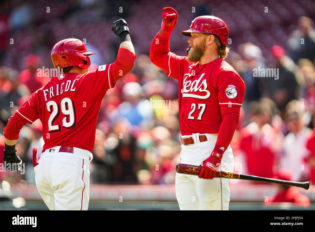 Cincinnati Reds' Jonathan India, right, celebrates with third base coach  J.R. House (56) after hitting a two-run home run during a baseball game  against the Milwaukee Brewers in Cincinnati, Friday, June 2