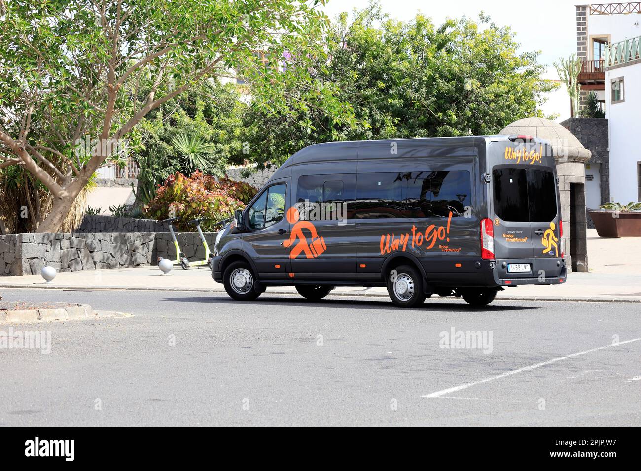 Black transfer mini bus with Way to Go! logo parked by the kerb. Lanzarote scene. February 2023 Stock Photo
