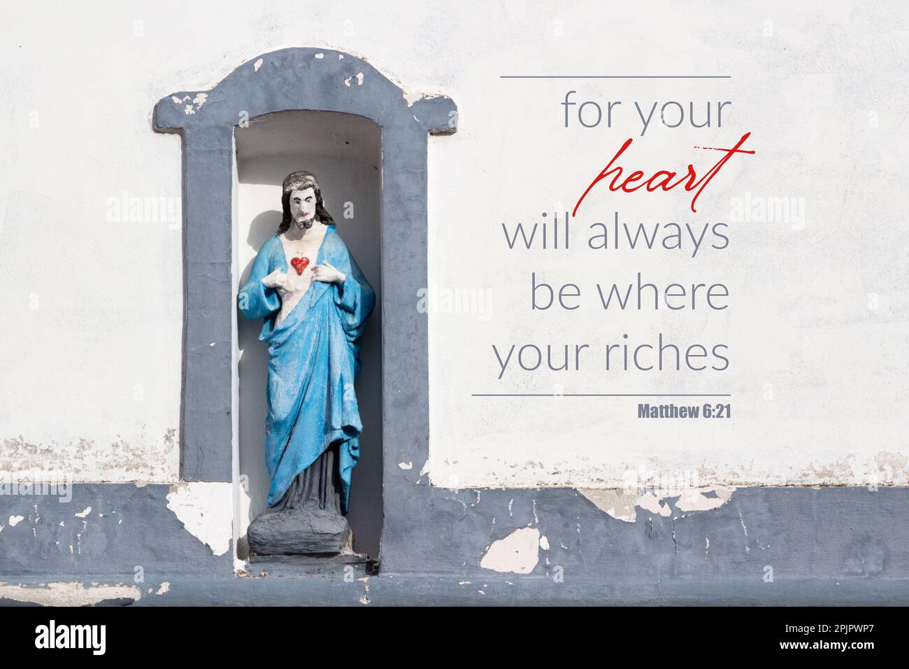 'For your heart will always be where your riches' Bible verse quote. Christ sculpture with red heart on rural house Stock Photo