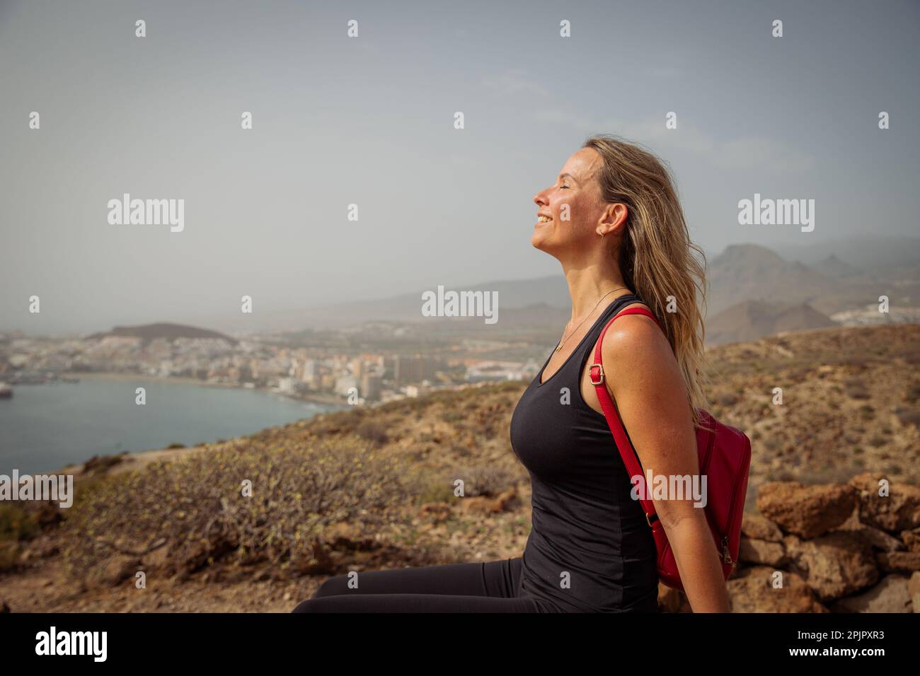A female hiker relaxes by breathing fresh air on a hike, nature lover. Stock Photo