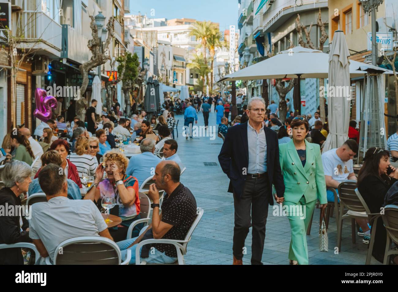 Benidorm, Spain - 01 April, 2023: People in crowdy streets of Benidorm old town. People relaxing in outdoors cafes. Benidorm - popular Spanish resort Stock Photo