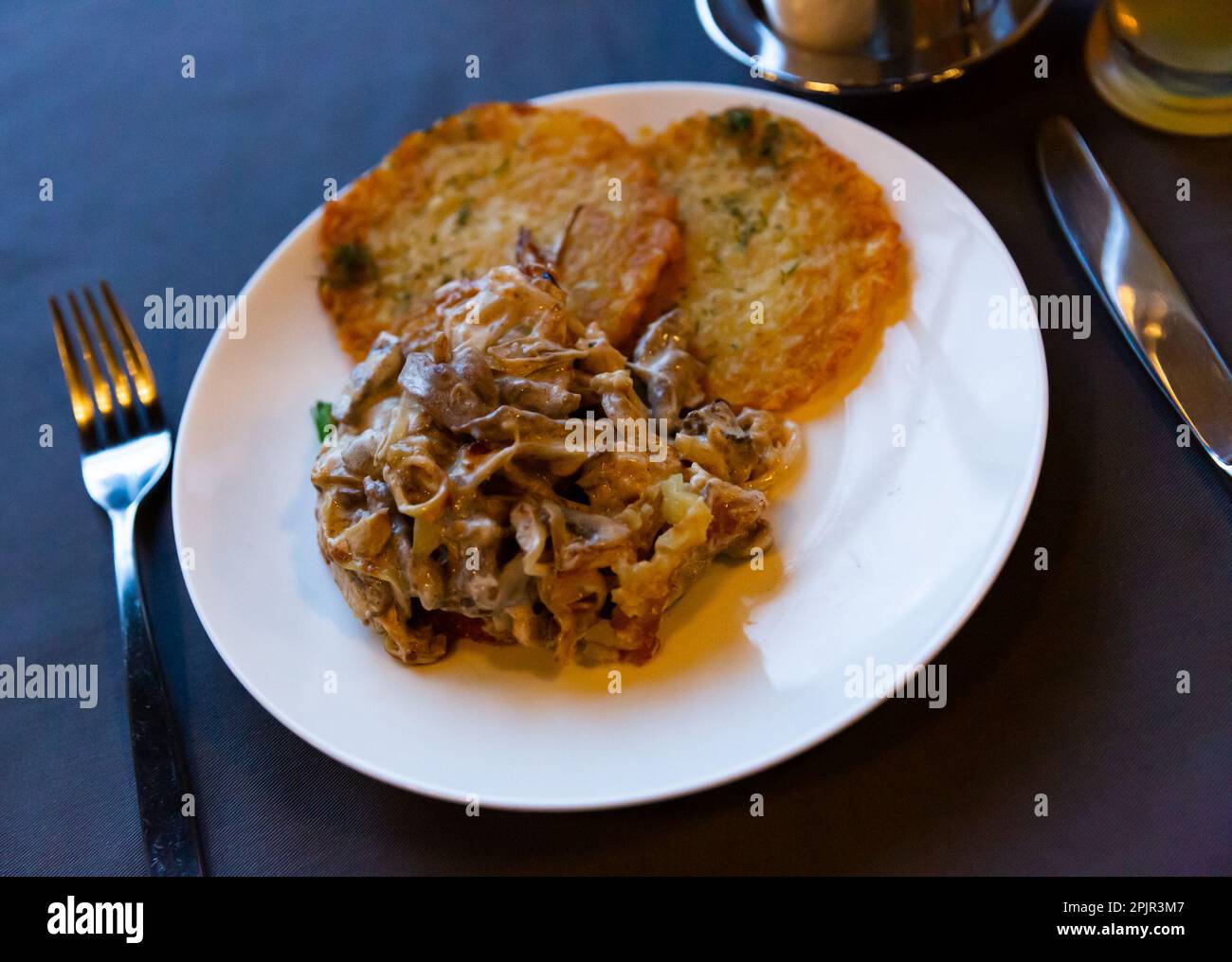 Fried beef in sour cream sauce with potato pancakes Stock Photo Alamy