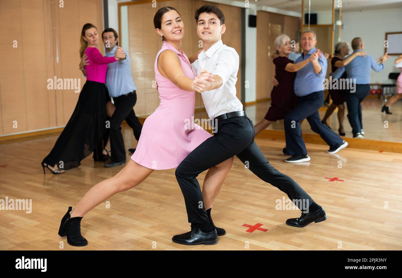 Young girl learning to dance waltz with guy in dancing class Stock