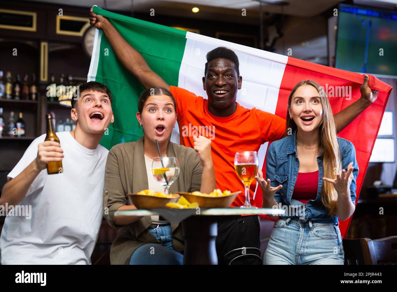 Happy multiracial people holding the flag of Italy and drinking beer in