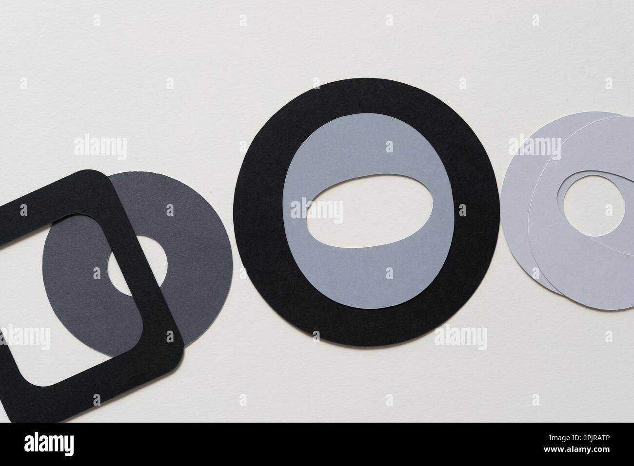 mostly a collection of paper rings in black and grey and square frame with rounded corners on blank paper Stock Photo