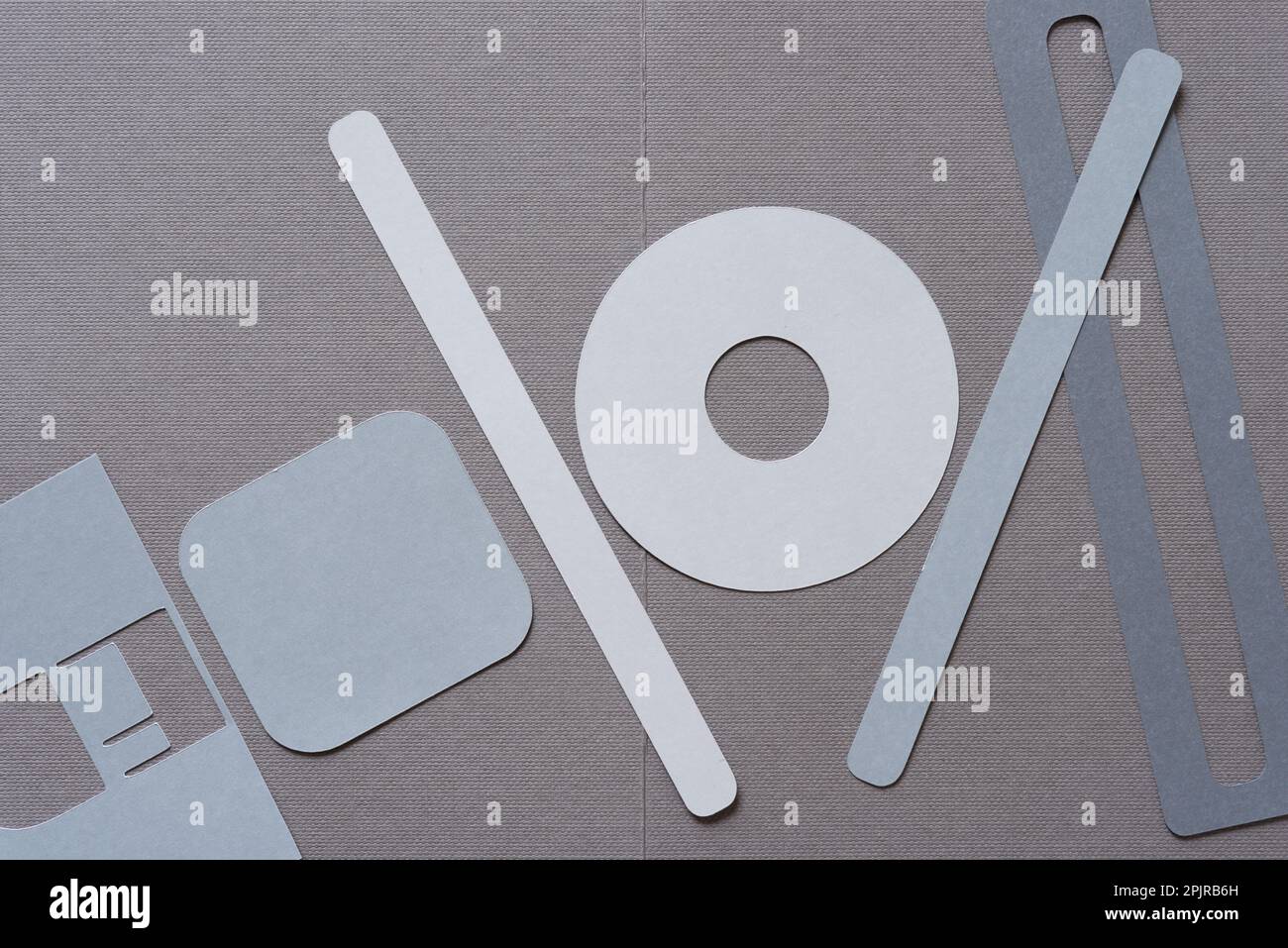 stencil with letters E (at least), square with rounded corners, ring, and sticks or various cut paper shapes on grey Stock Photo