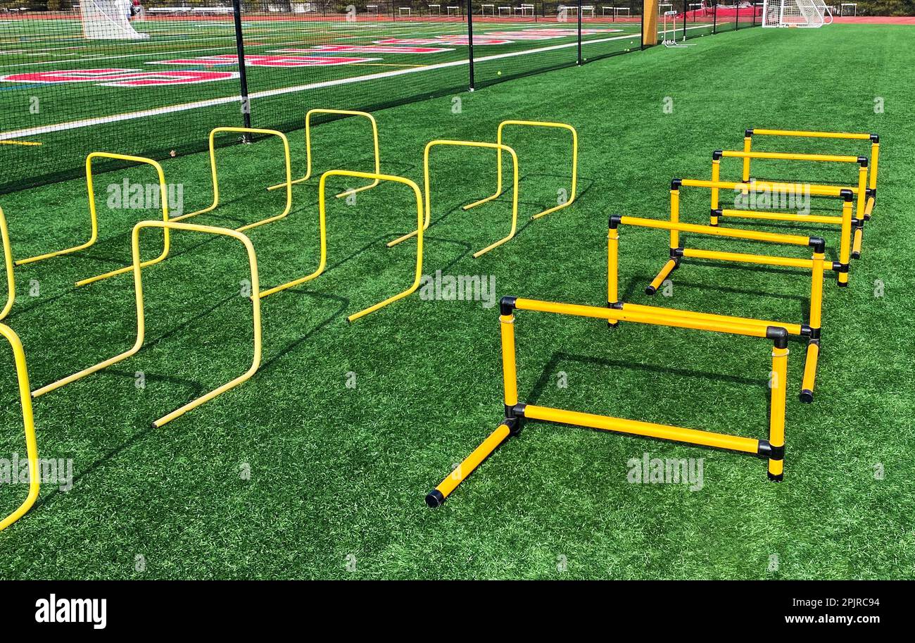 Three rows of plastic hurdles set up for athletes to jump over suring