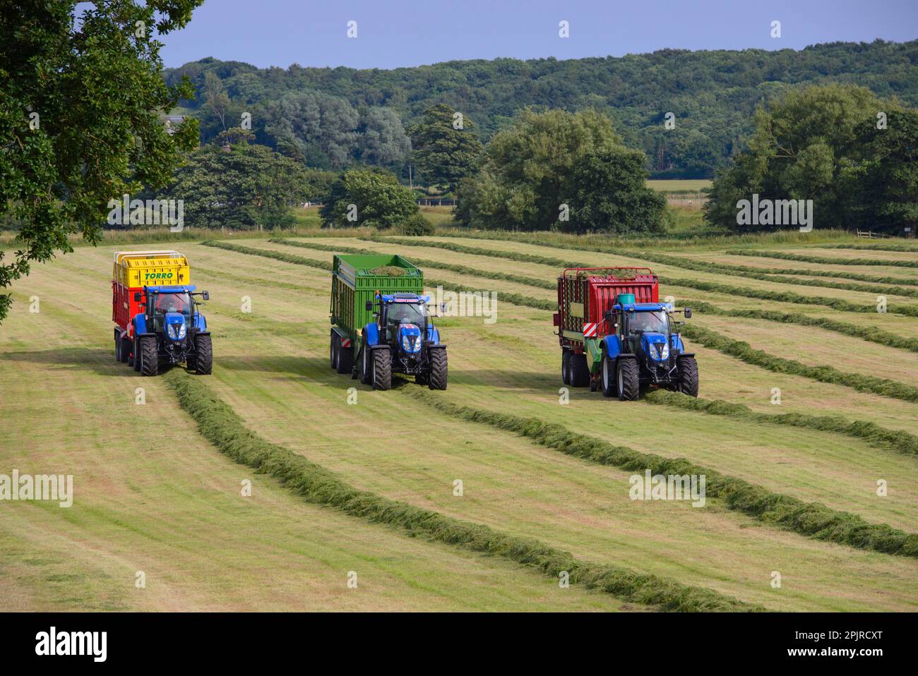 Three tractors with feed wagons picking up cut grass, Grimsargh