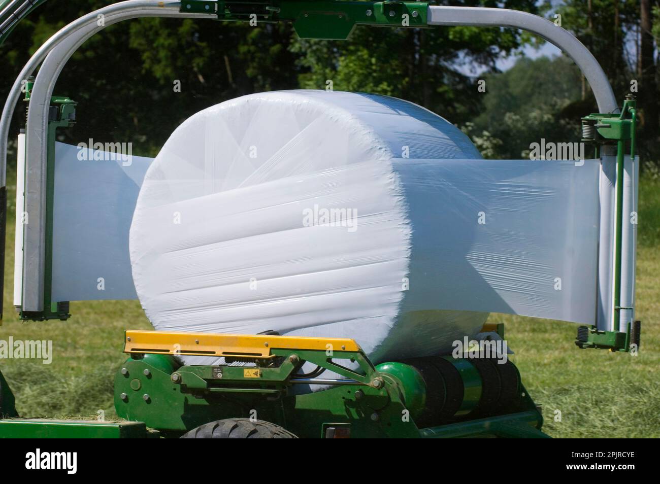 Plastic wrapping round silage bales with mechanical bale wrapper