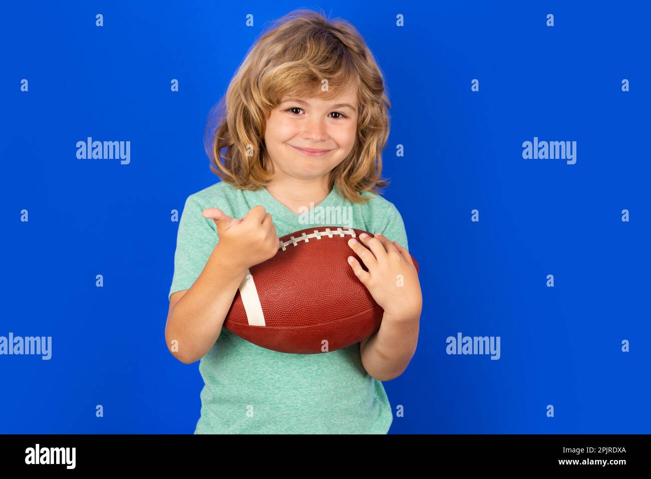 Kids and sports. Boy with rugby ball. Young boy playing american