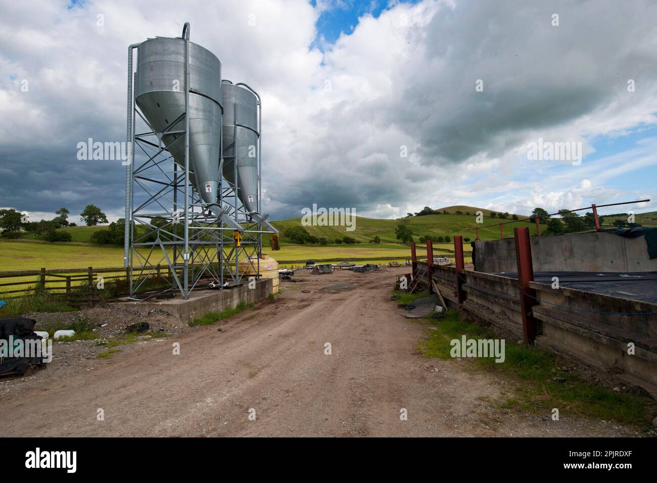 Farmyard with two bulk feed hoppers for animal feed, Yorkshire, England