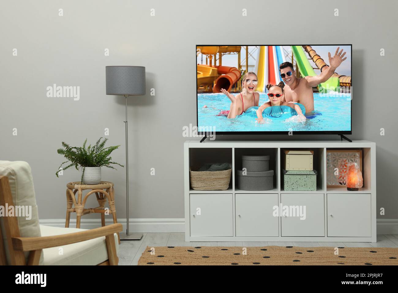 Modern TV set on wooden stand in room Stock Photo