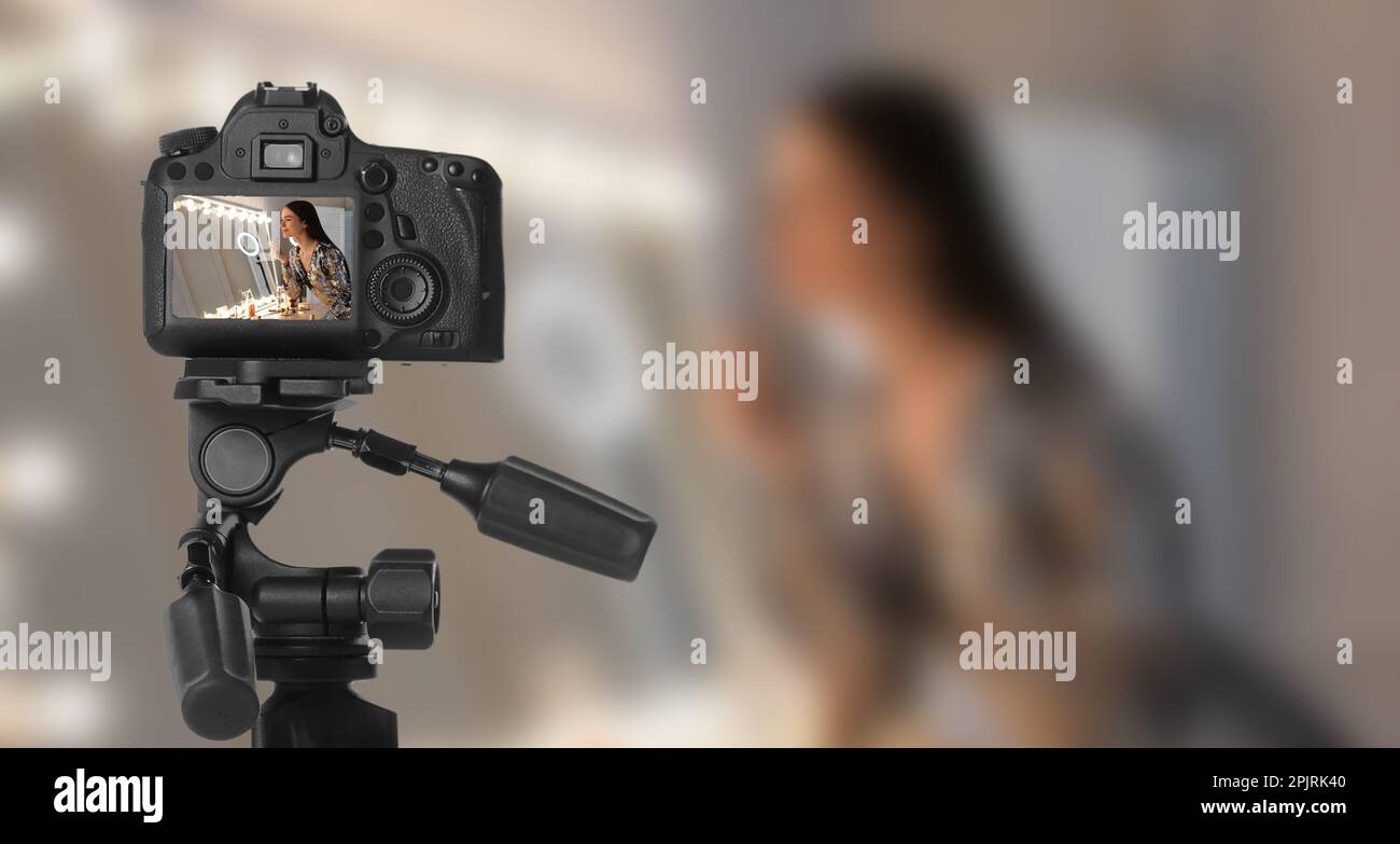 Young woman applying make up, selective focus on camera display Stock Photo