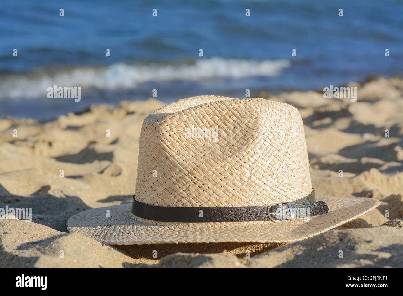Stylish straw hat on sandy beach near sea Stock Photo - Alamy