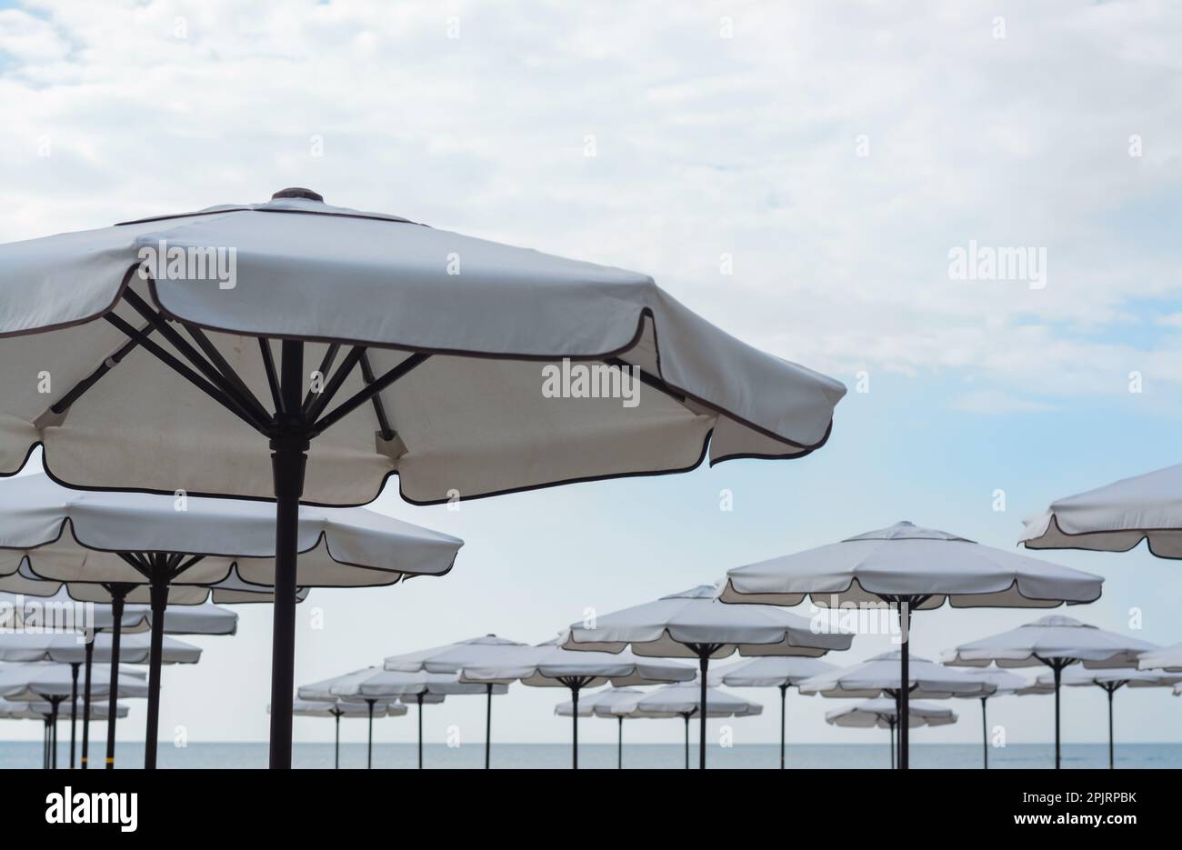 Beautiful white beach umbrellas against blue sky Stock Photo