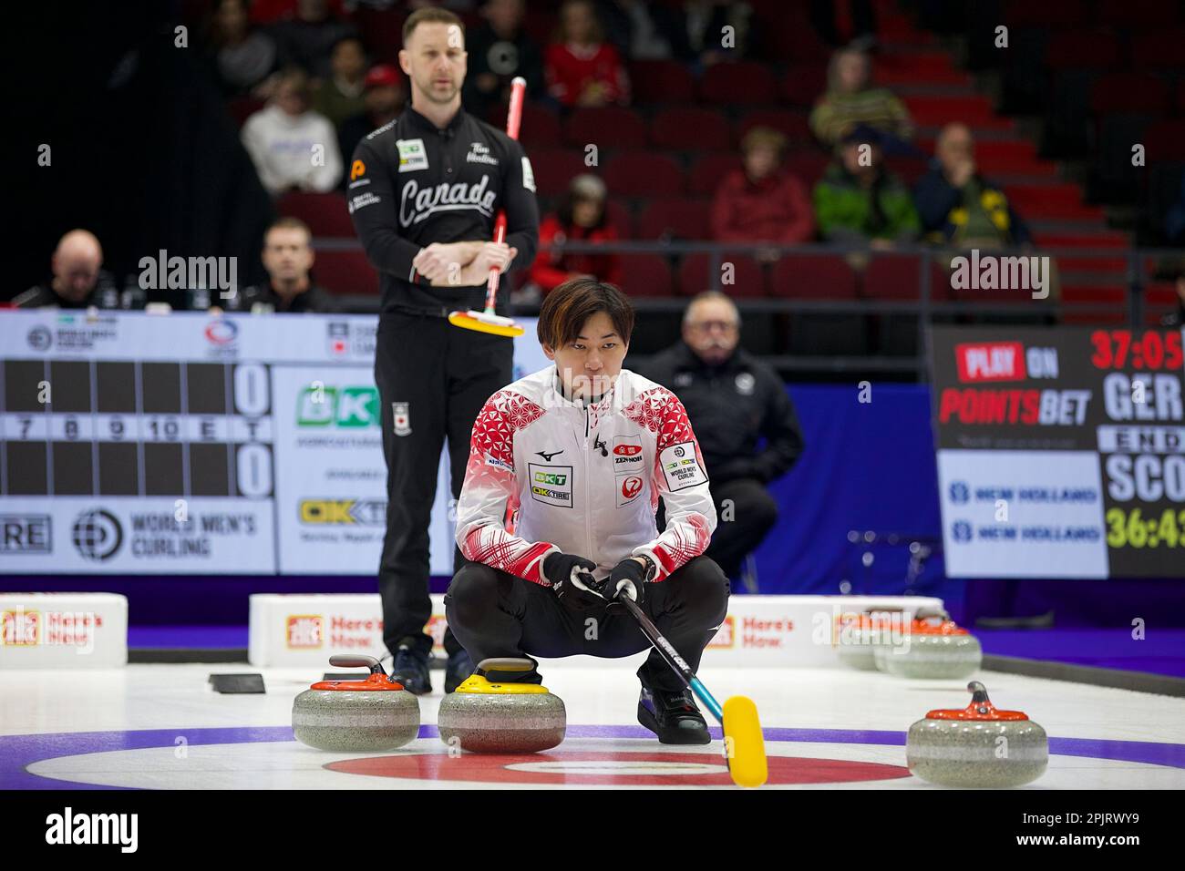Team Japans Riku Yanagisawa lines up a shot against Team Canadas Brad Gushue (rear) at 2023 World Mens Curling Championship in Ottawa, Ontario, Canada on April 3, 2023