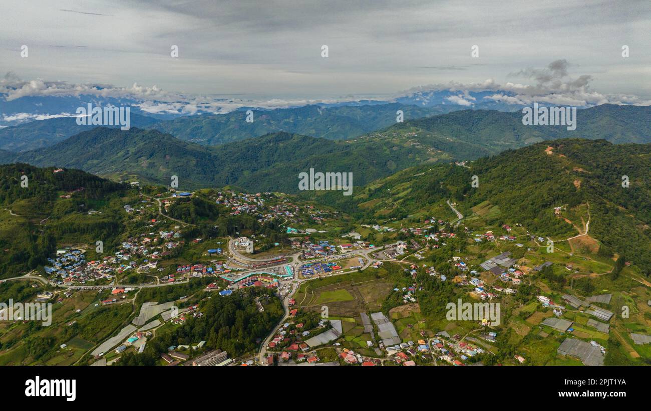 Aerial drone of city is located in the mountains among farmland at the ...