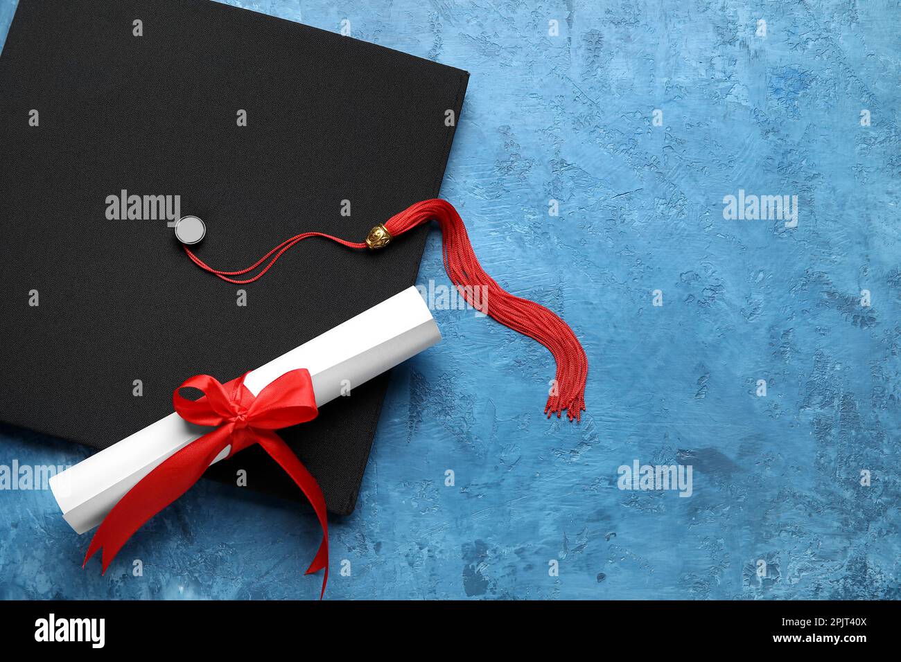 Red Ribbon Graduation Diploma with red ribbon and graduation hat on blue table Stock Photo ...