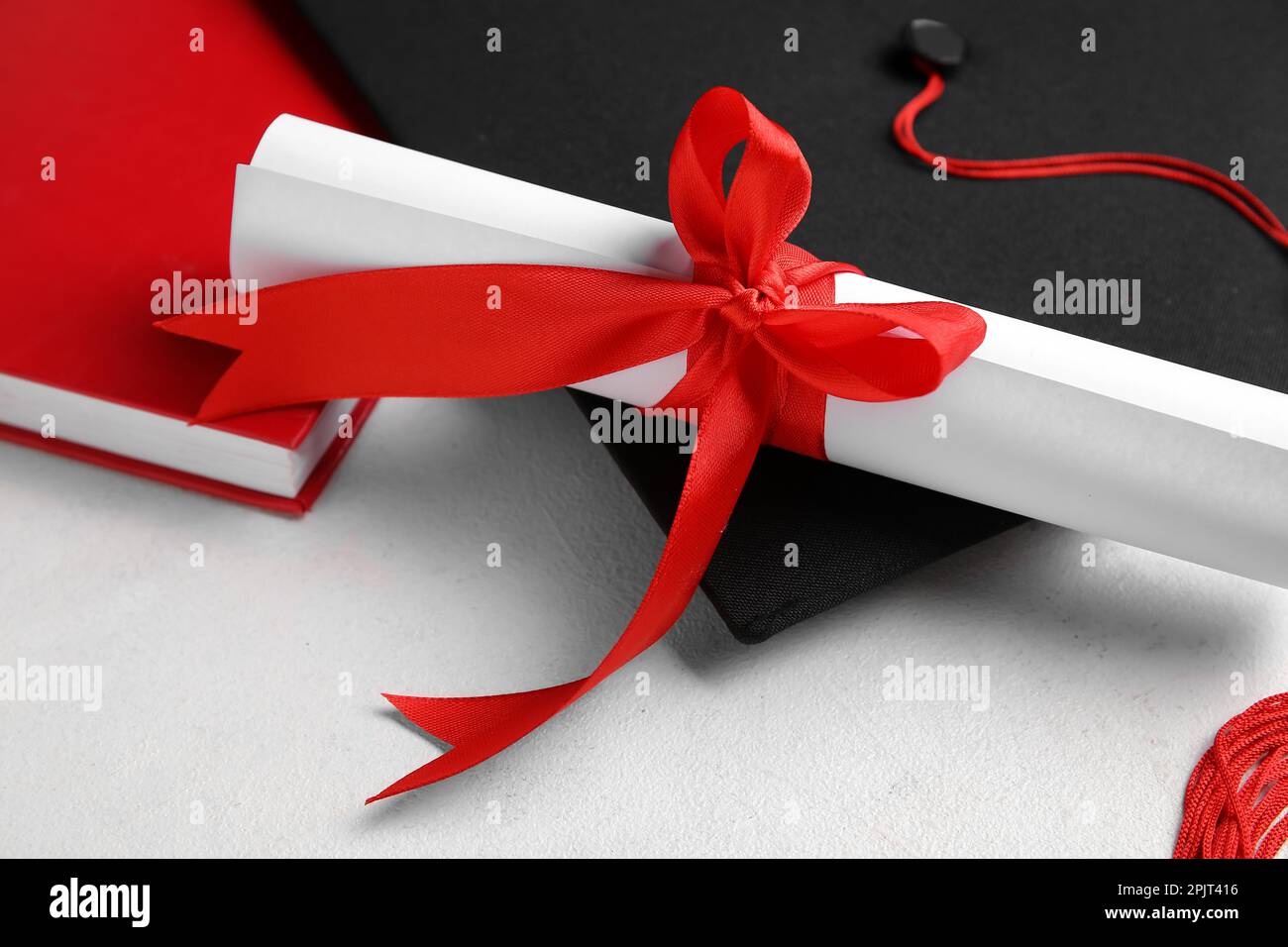 Red Ribbon Graduation Diploma with red ribbon and graduation hat on white table Stock Photo ...