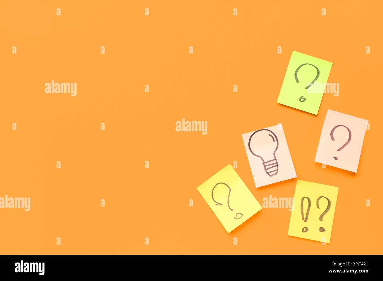 Sticky papers with drawn question marks and light bulb on red ...