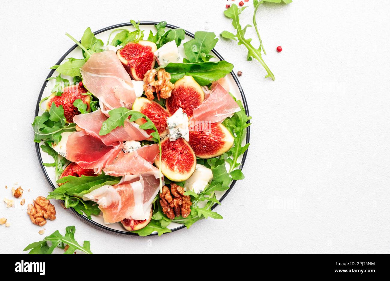 Summer salad with sweet figs, prosciutto, cheese, walnuts
