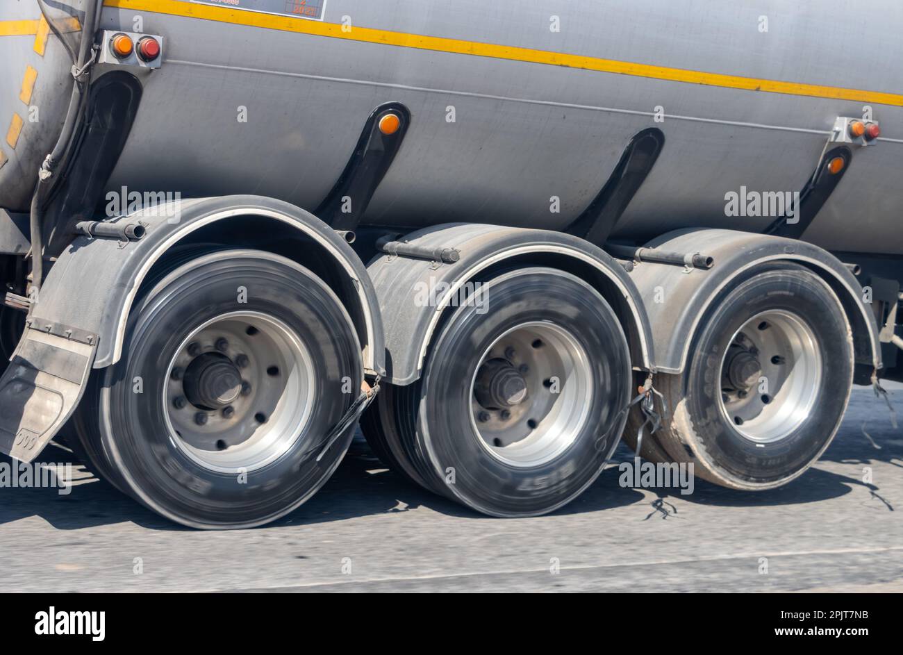 View of the rear wheels of a cistern truck while driving with the axle raised Stock Photo