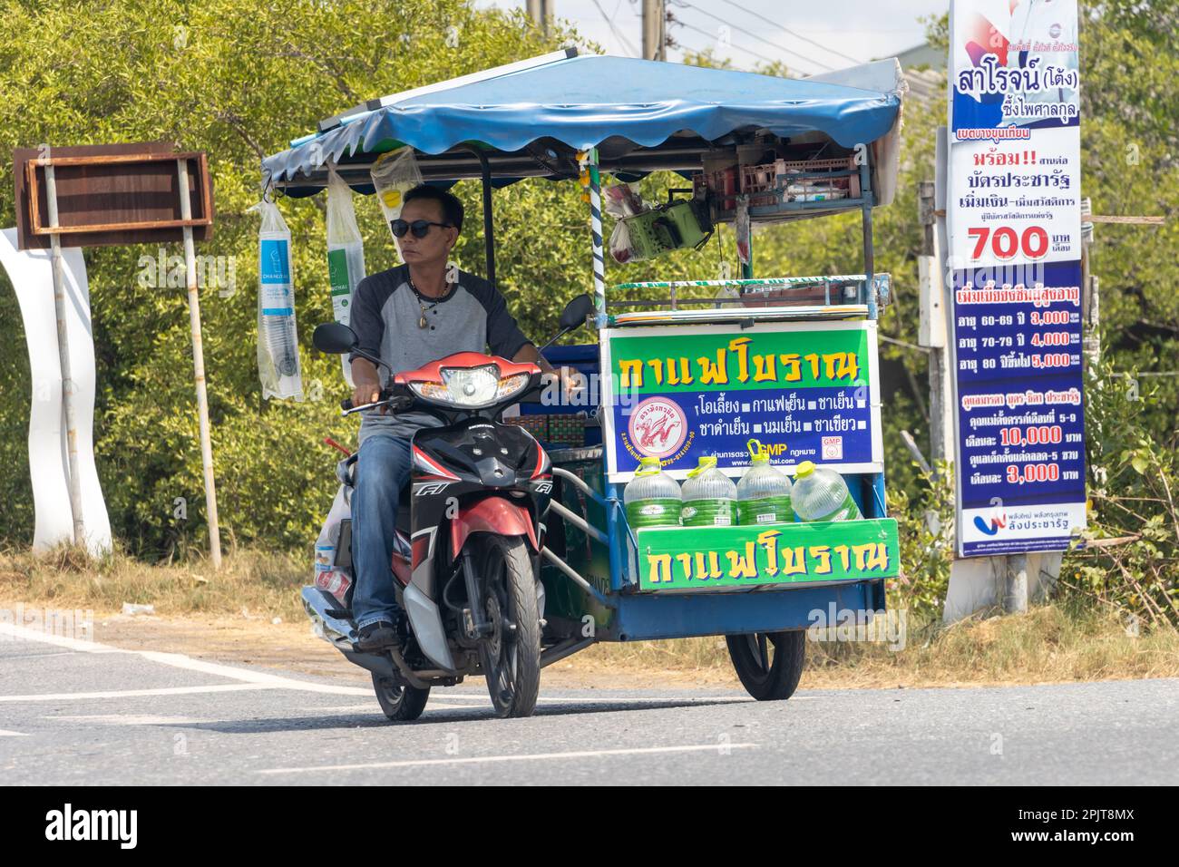 BANGKOK, THAILAND, MAR 24 2023, Seller chilled drinks drives a sidecar on the road Stock Photo