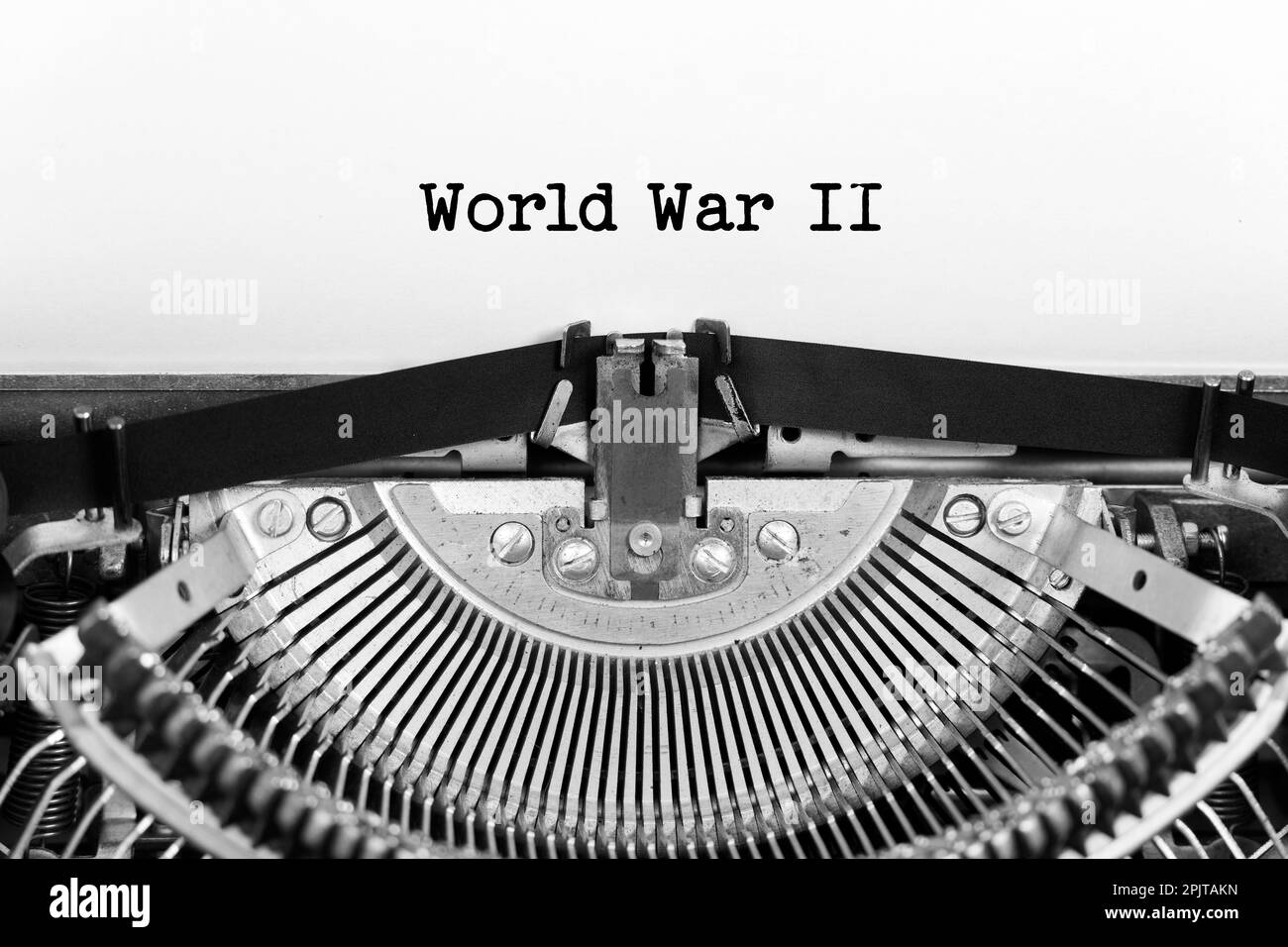 World War 2 word closeup being typing and centered on a sheet of paper on old vintage typewriter mechanical Stock Photo