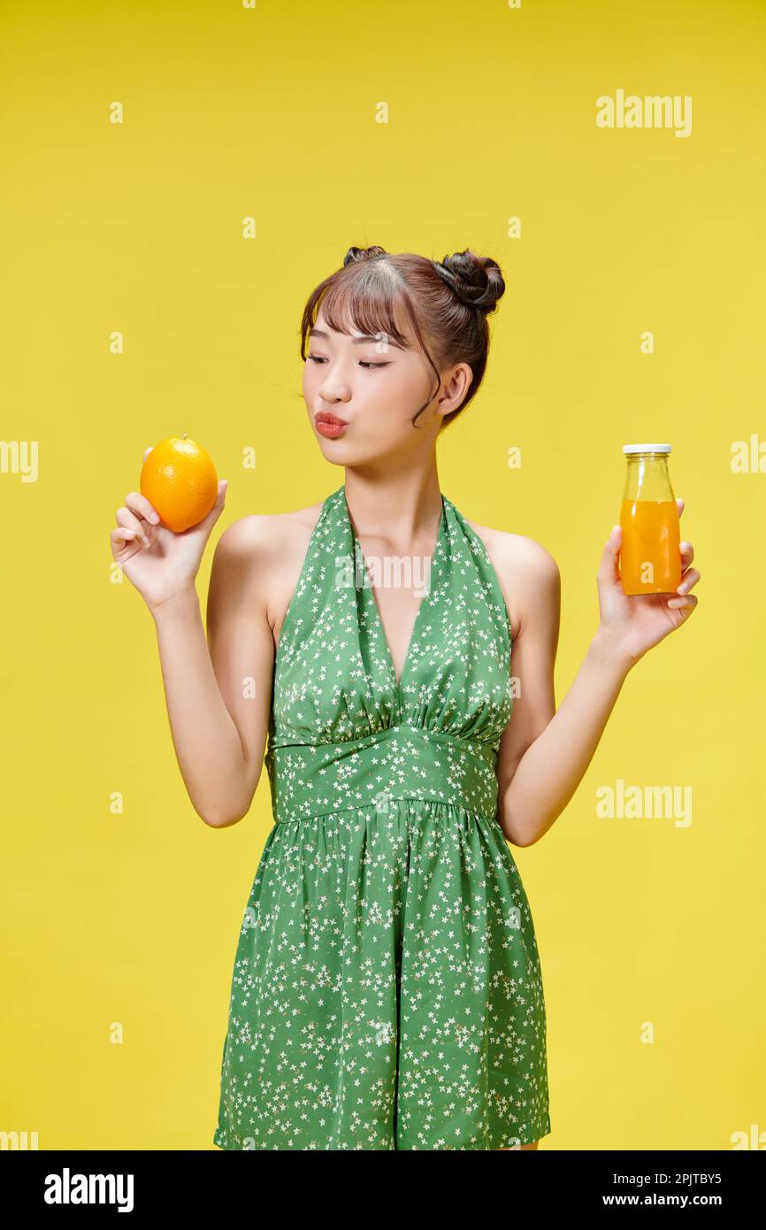 Tropical fruits season. Positive girl holding fresh orange and juice ...