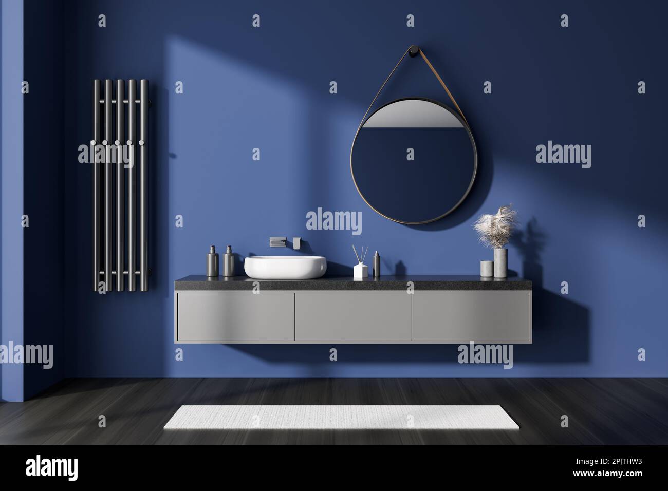 Dark blue bathroom interior with sink and round mirror, drawer and ...