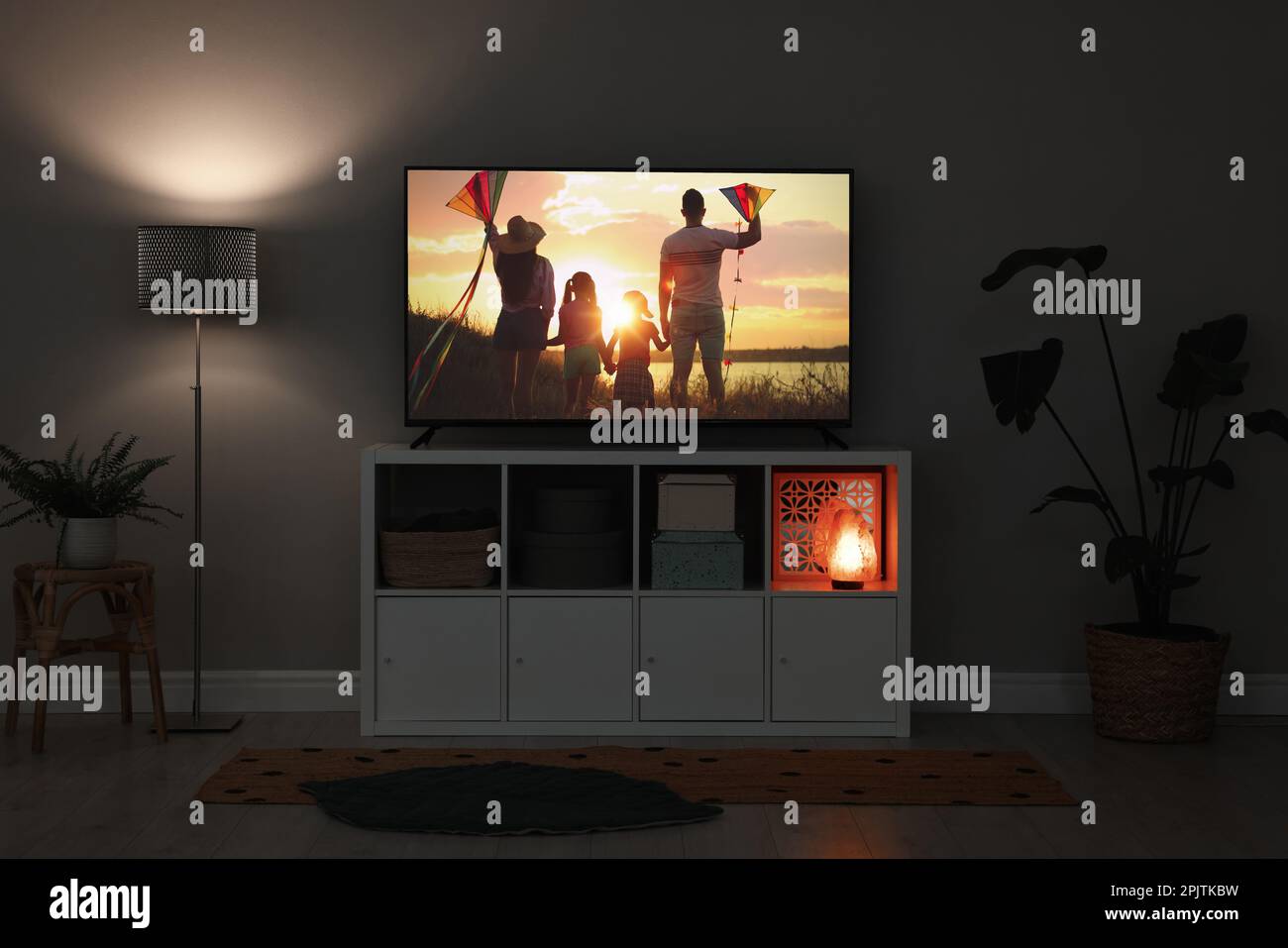 Modern TV set on wooden stand in room Stock Photo